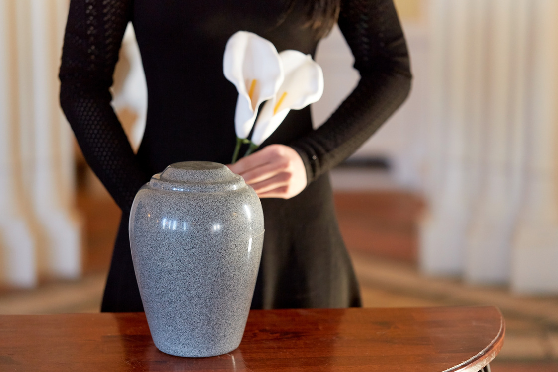 Woman with Cremation Urn at Funeral
